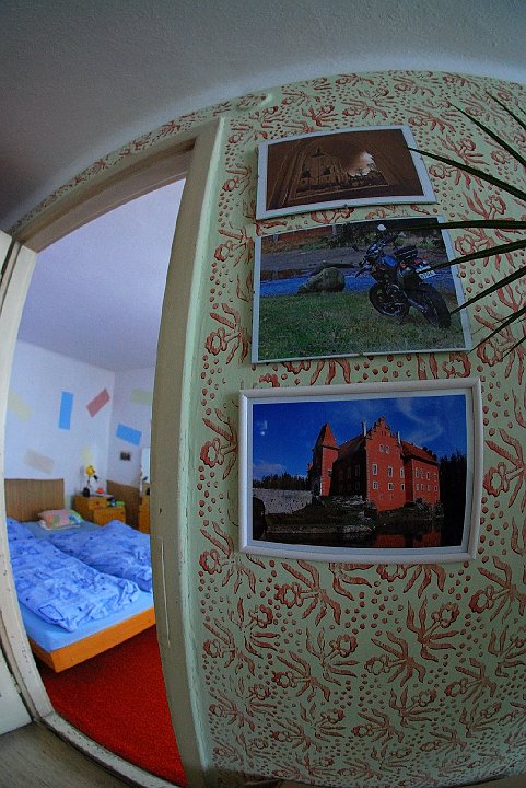 DSC_9273_1.JPG - Stěny obývacího pokoje jsou kromě zmíněných válečků  vkusně vyzdobeny uměleckými fotografiemi. Tyto pochází samozřejmě z rukou (a fotoaparátu) p.ř. Ve dveřích můžeme zahlédnout lůžko p.ř. (to vlevo), kde odpočívá po namáhavé práci ve firmě L.N.D. Celý interiér rodného domu je příjemně zakulacený.